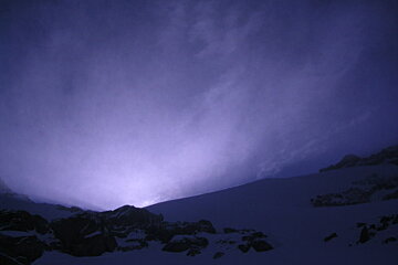 A purple sky with a mountain in the foreground