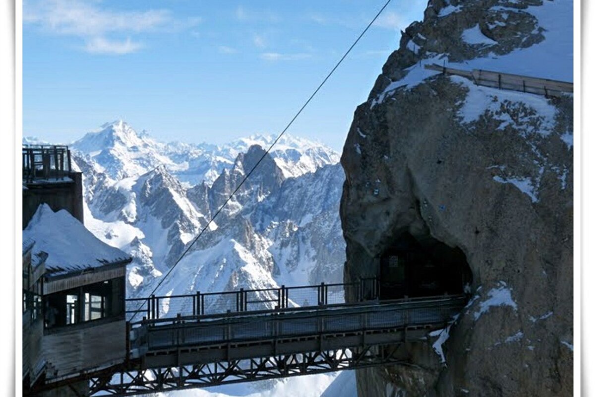 A bridge over a cliff with mountains in the background