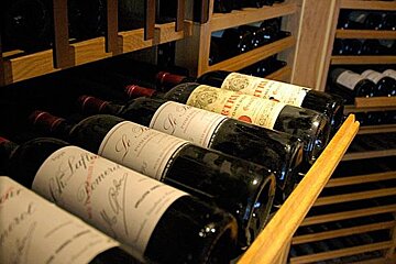 Several bottles of wine are lined up in a wine cellar