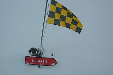 A sign that says les arbis is covered in snow