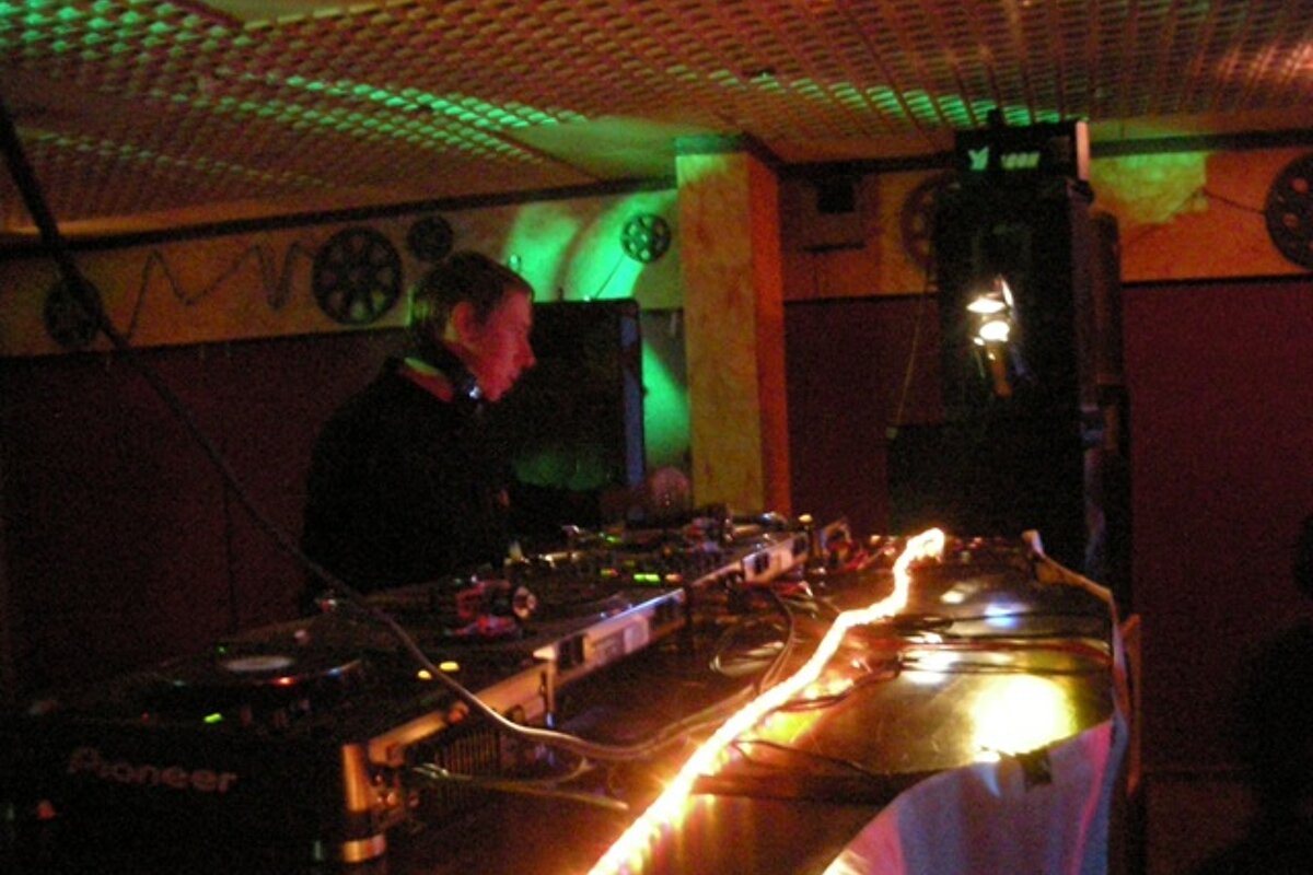 A man is playing music on a pioneer machine