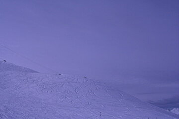 A snowy mountain with a blue sky in the background