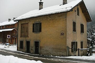 A snowy house with a sign that says rue de la montagne