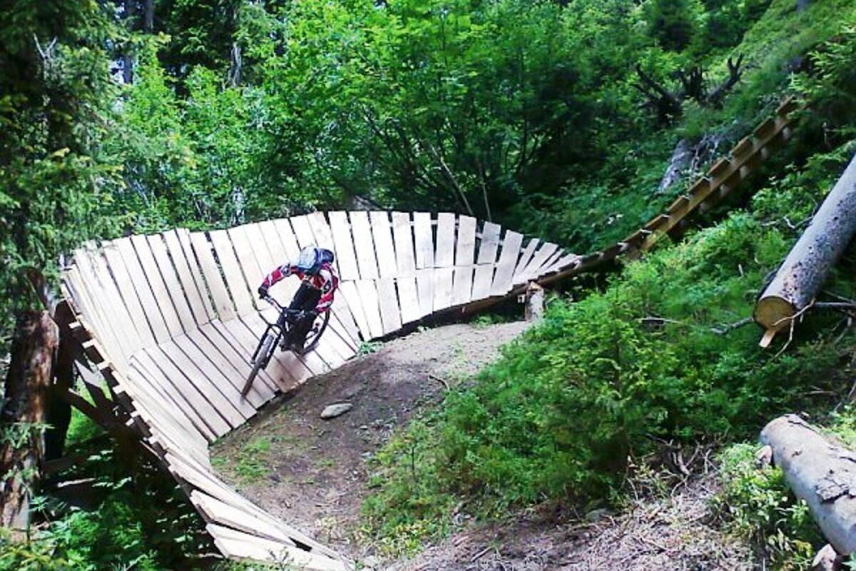 A person riding a bike on a wooden bridge