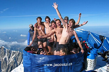 A group of people are in a jacuzzi on top of a mountain