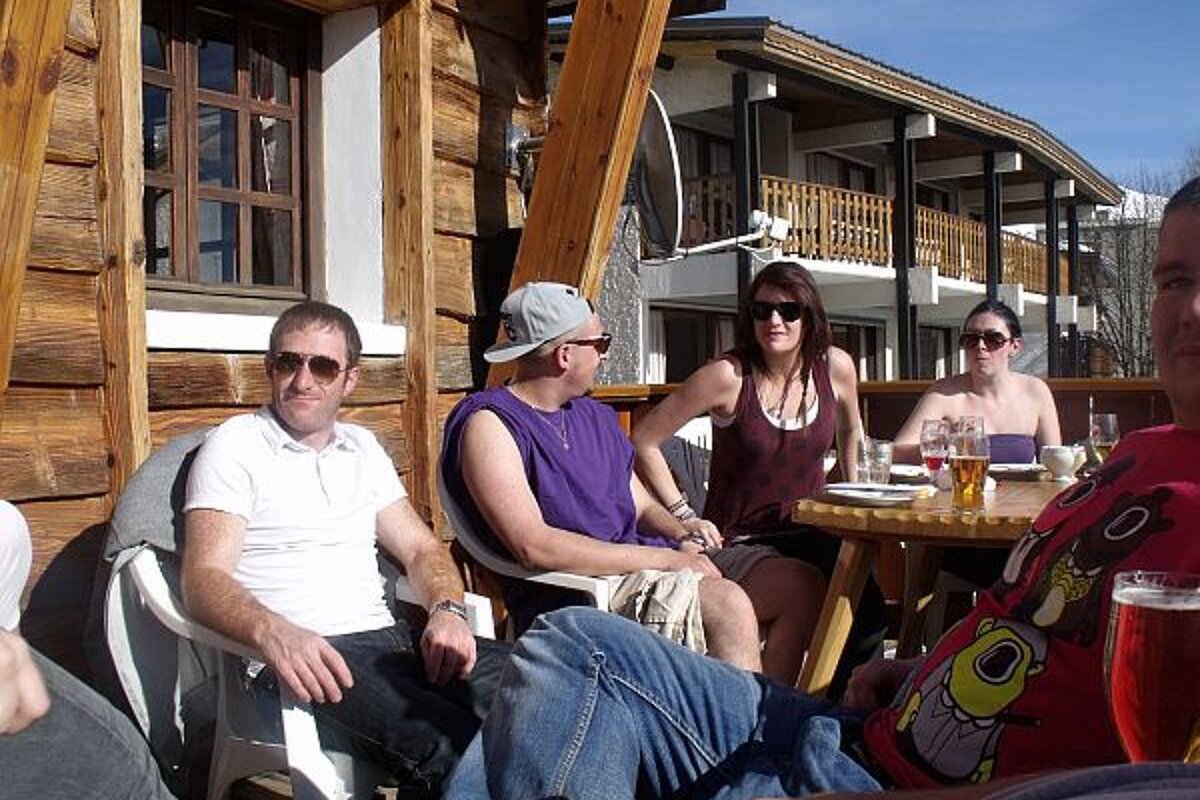 A group of people sitting around a table with glasses of beer