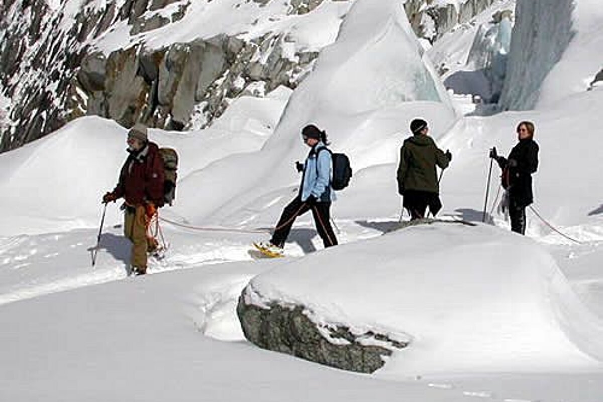 A group of people are walking through the snow