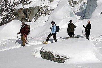 A group of people are walking through the snow