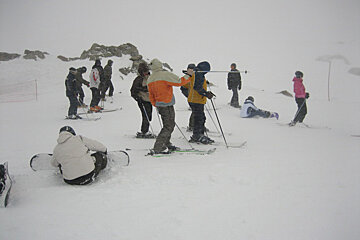 A group of people skiing and snowboarding on a snowy slope
