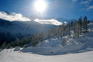 The sun is shining brightly over the snowy mountains