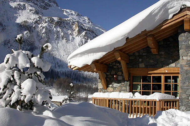 A snowy house with a mountain in the background