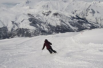 Skier skiing down snowy piste in Meribel