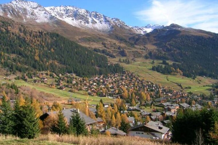 A small village in the mountains with a mountain in the background