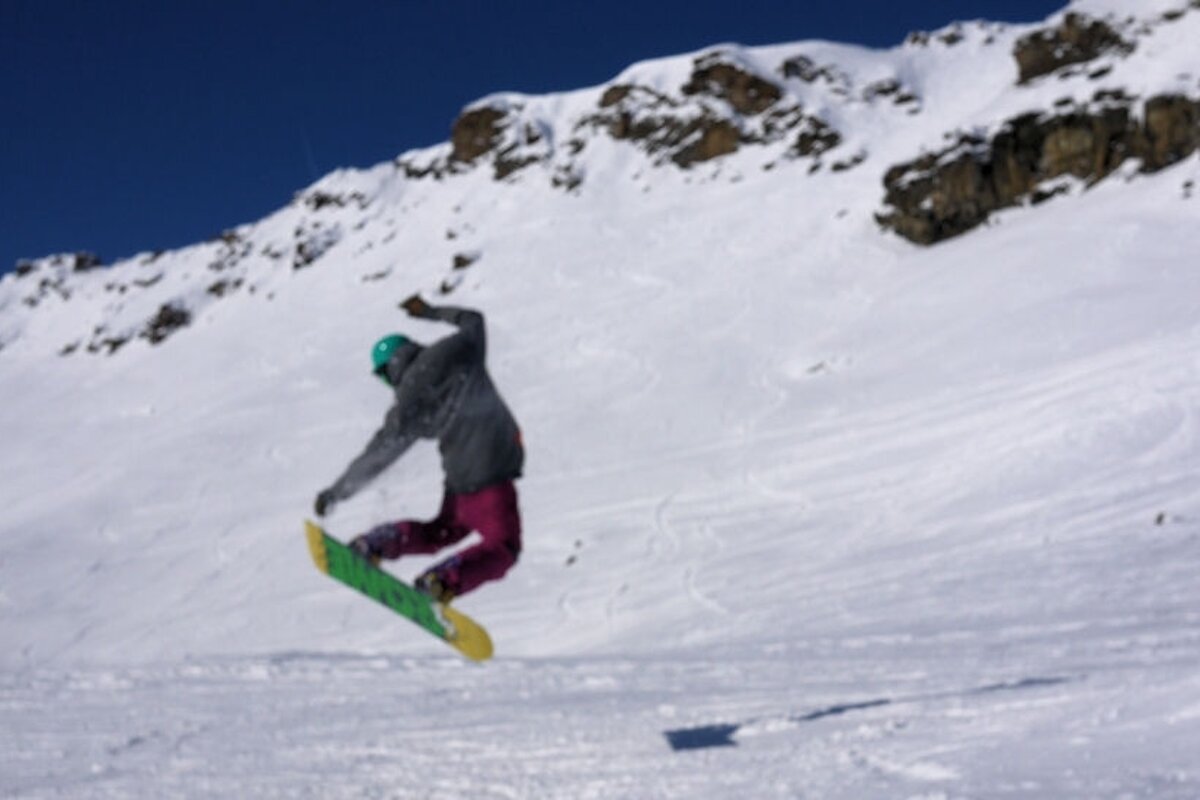An image of a snowboarder getting some air off-piste
