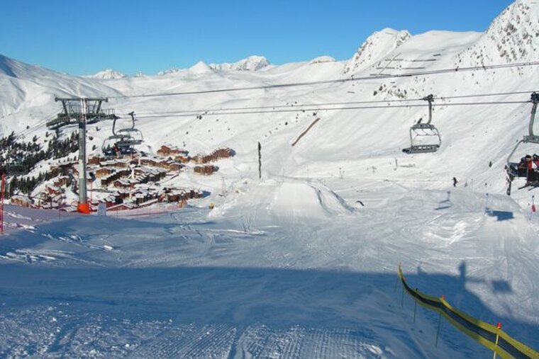 A ski lift is going up a snowy mountain