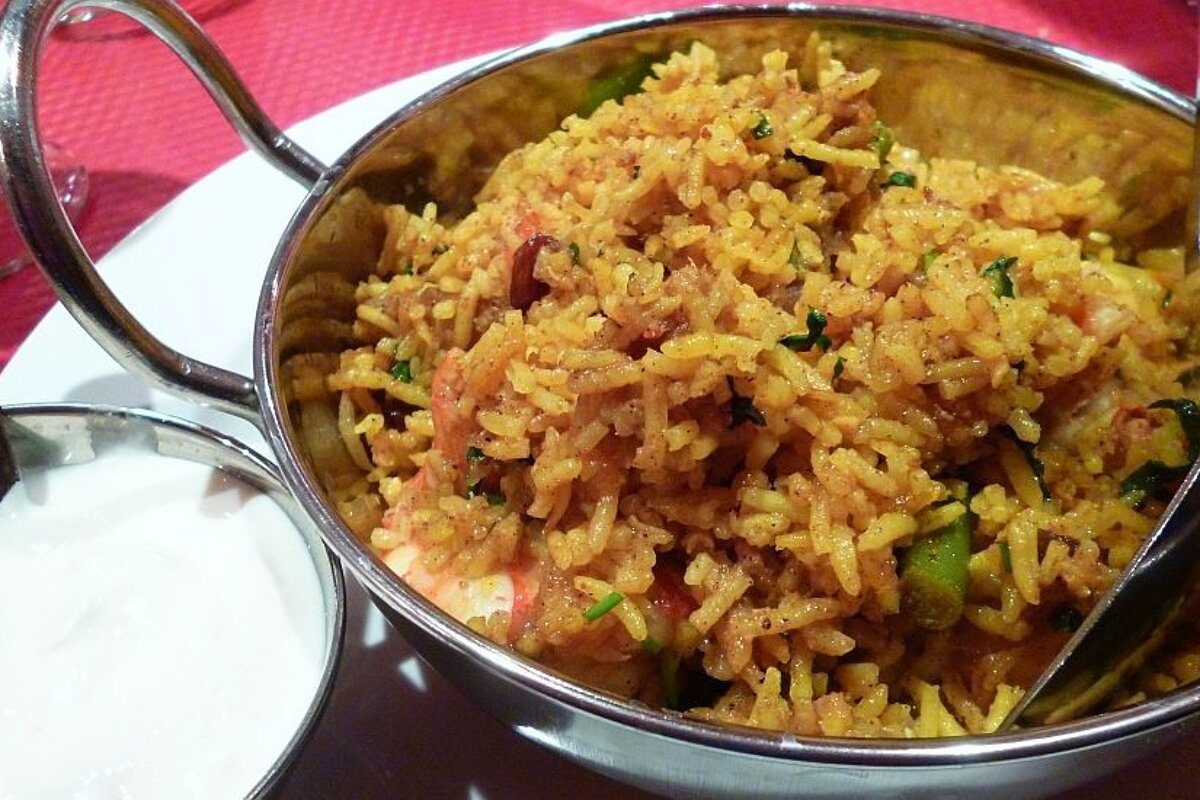 An image of a curry and rice in a bowl with a dip on the side