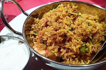 An image of a curry and rice in a bowl with a dip on the side