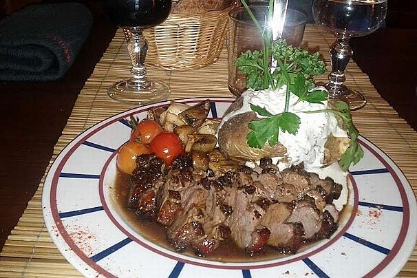 A plate of food with meat and vegetables on a table