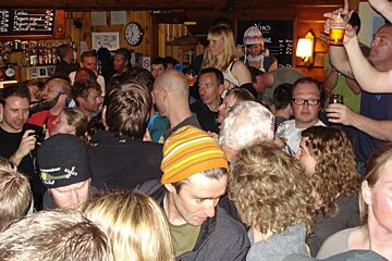 A crowd of people are gathered in front of a sign that says vins