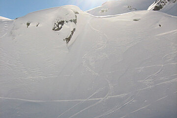 A person skiing down a snowy slope on a sunny day