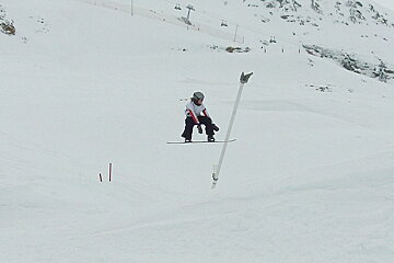 A snowboarder is doing a trick on a snowy slope