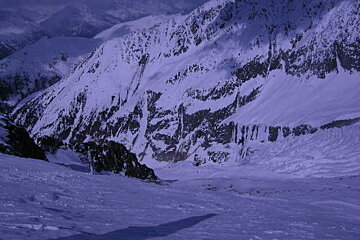 A snowy mountain with a purple sky in the background