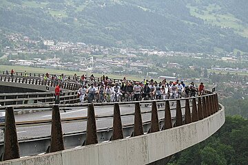 A group of people are riding bikes on a bridge