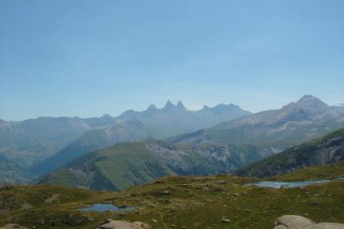A view of a mountain range with a blue sky in the background