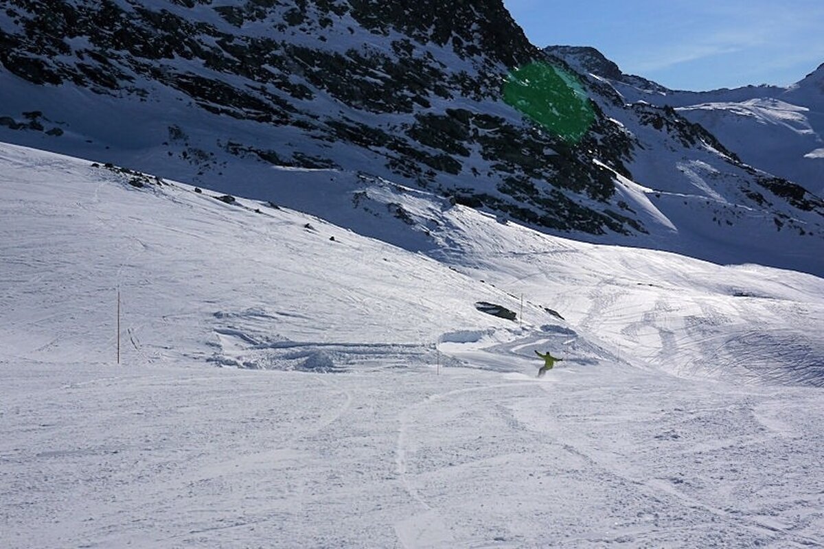 An image of a snowboarder getting some speed on a firm run