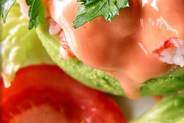 A close up of a sandwich with lettuce , tomatoes and sauce