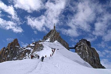 A group of people are climbing up a snow covered mountain