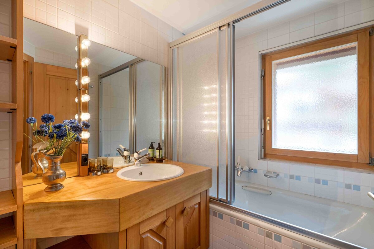 A bathroom with a sink a mirror and a window