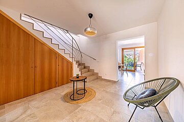 A chair sits in a hallway next to a staircase