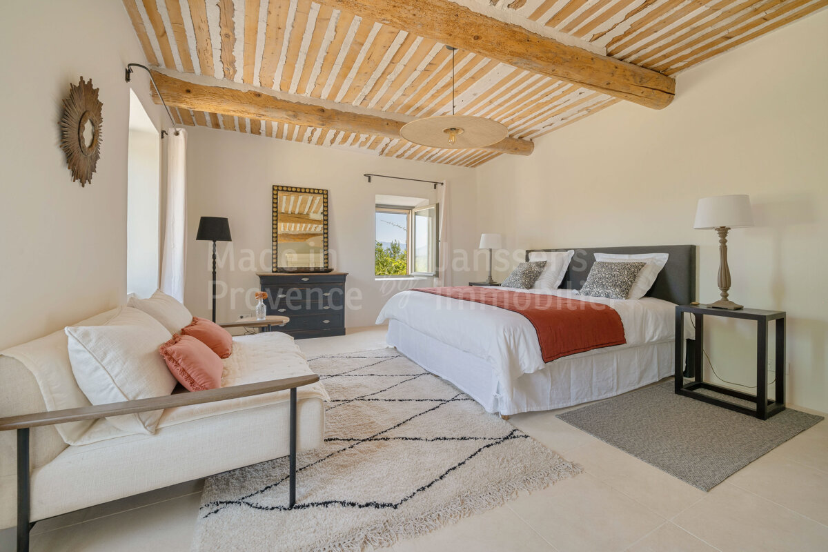 A bedroom with a bed and a couch and the word provence on the bottom