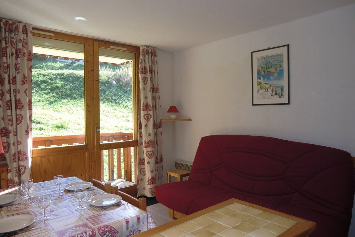 A living room with a couch a table and a picture on the wall