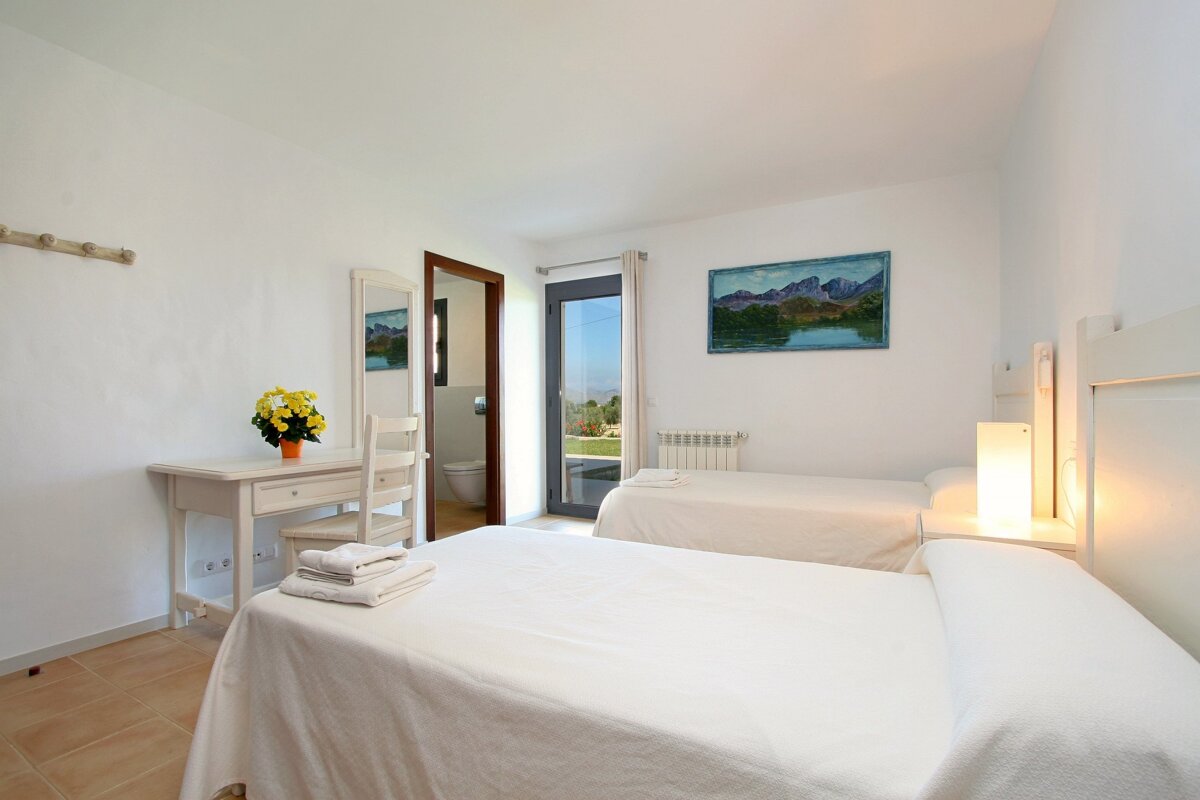 A bedroom with two beds and a painting on the wall