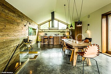 A dining room with a wooden table and chairs