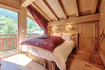 A bedroom with a large bed and a balcony