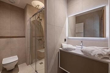 A bathroom with a toilet a sink and a mirror
