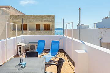 A balcony with a table and chairs and a samsung air conditioner