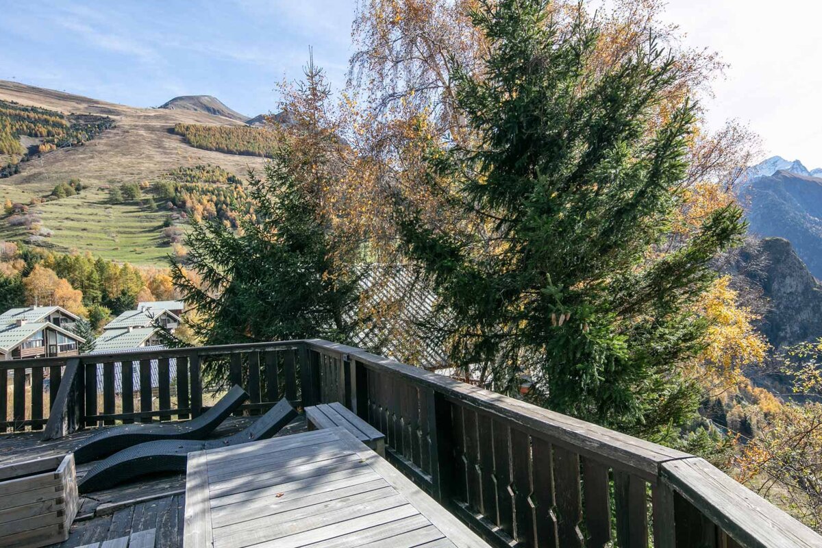 A balcony with a view of mountains and trees