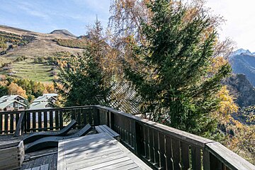 A balcony with a view of mountains and trees
