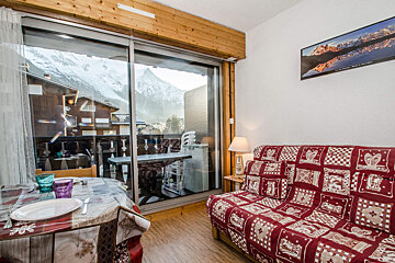 A living room with a couch a table and a picture on the wall