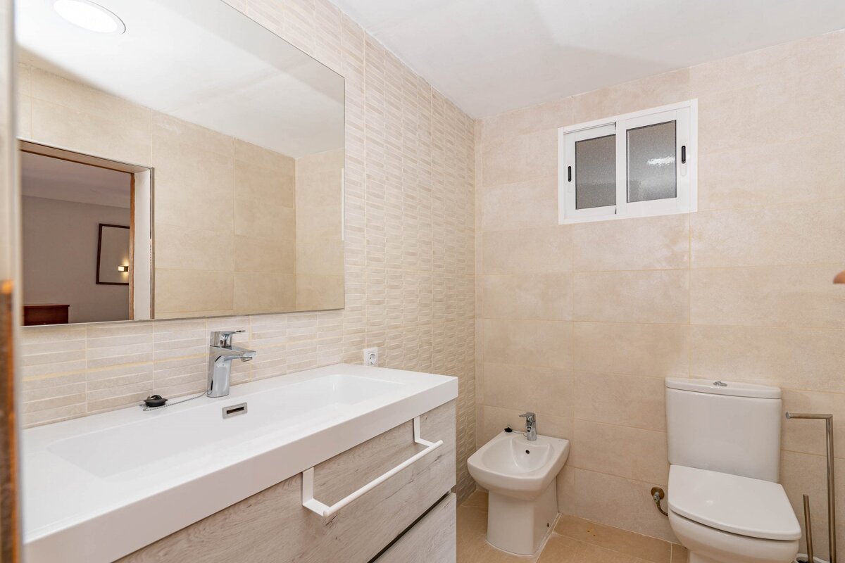 A bathroom with a sink toilet and bidet