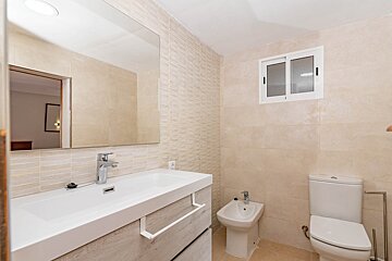 A bathroom with a sink toilet and bidet