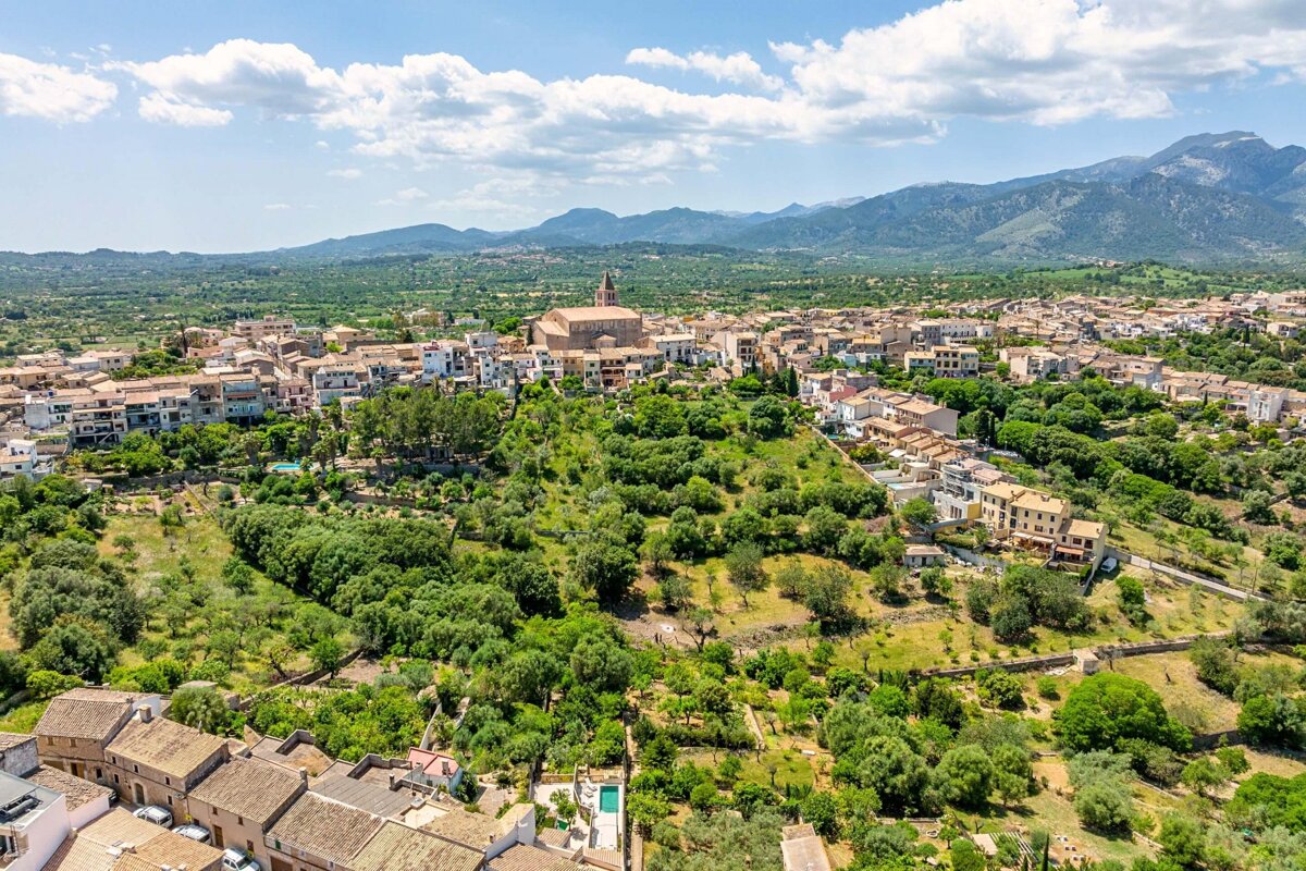 An aerial view of a small town with mountains in the background
