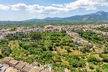 An aerial view of a small town with mountains in the background