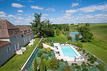 An aerial view of a large house with a swimming pool
