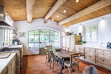 A kitchen with a wooden table and chairs and a large window