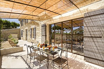 A patio with a table and chairs in front of a building that says saisons immobilier